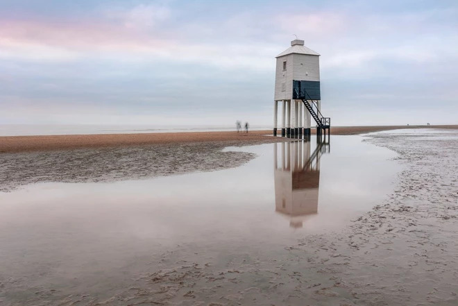 a mini tower on the beach during low tide